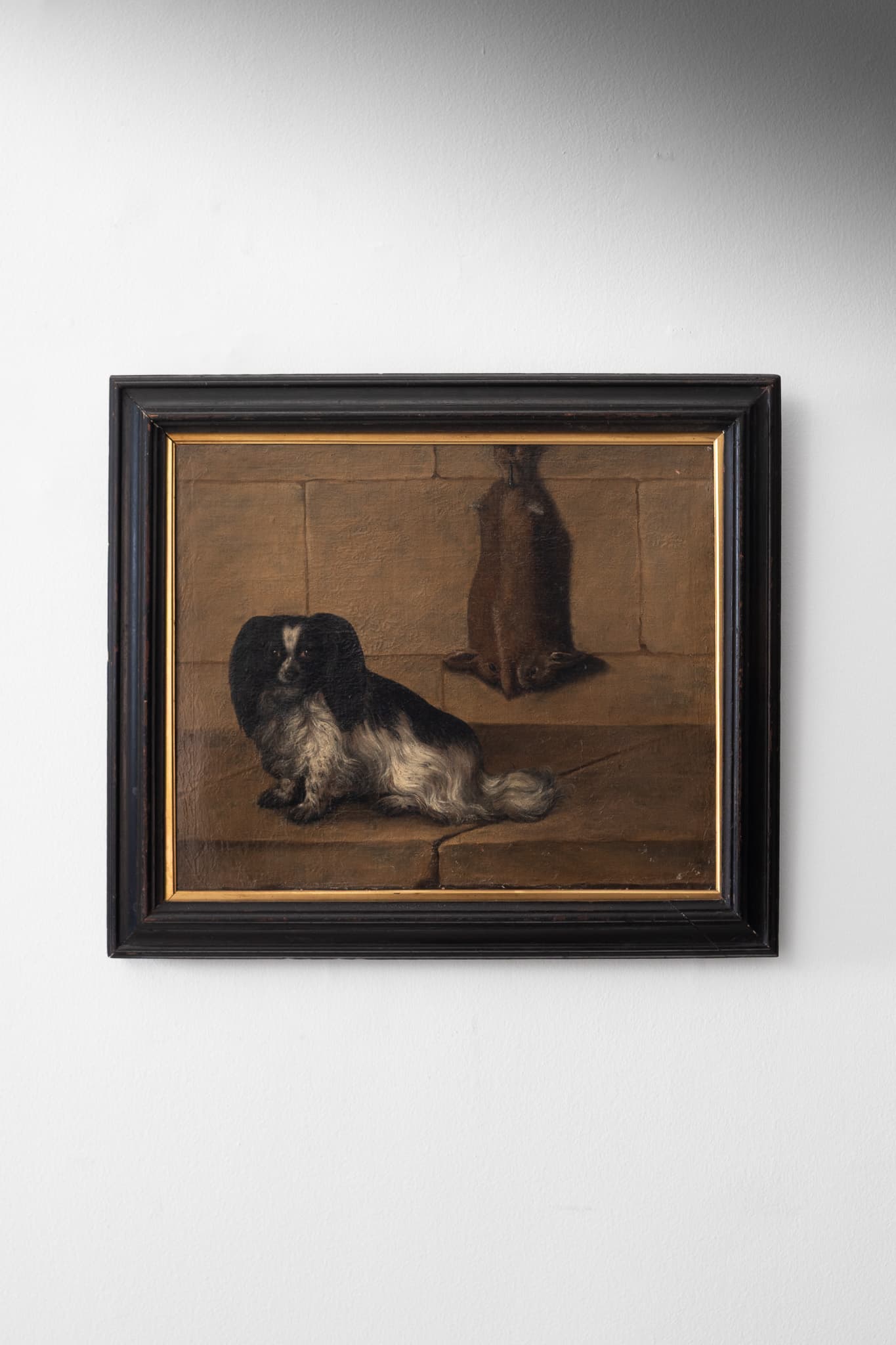 A Spaniel by Two Rabbits Hanging on a Stone Wall
