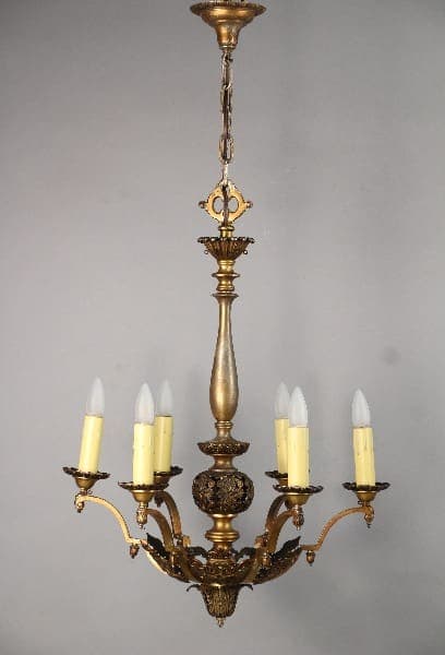 10489. Larger Scale 1920's 6-light Chandelier with five candle-like lights, detailed carvings, suspended from a chain against a gray background.