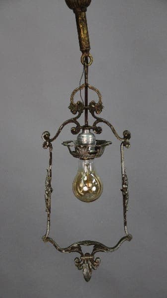 An antique hanging oil lamp with ornate metal frame and a glass bulb, suspended from a decorative chain. (Product Name: 12700. Single Downlight Pendant Circa 1920's)