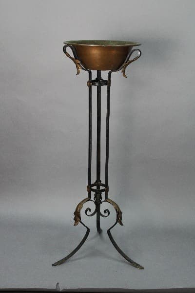 14066. 1920's Wrought Iron Plant Stand With Copper Bowl on a tall, wrought iron stand with decorative leaf motifs, against a plain gray background.