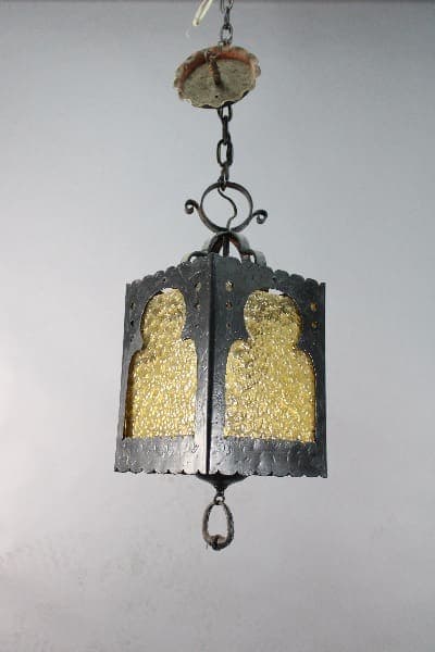 An antique Moorish Wrought Iron Pendant with Amber Glass, hanging from a chain.