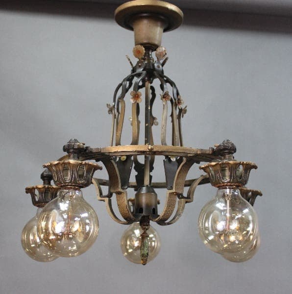 An antique 14527. 1920's 5 Light Chandelier With Original Finish with floral and lion motifs, holding four illuminated glass globes.
