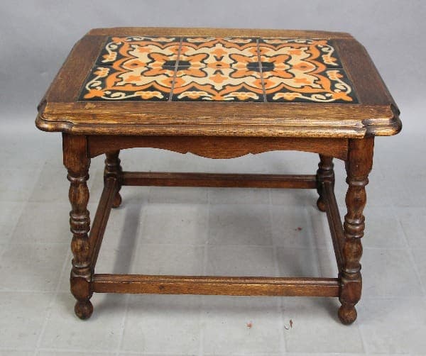 15317. 1920's Early California Monterey Style Spanish Revival Tile Table With 6 Tiles, featuring a square top with a decorative ceramic tile inlay in orange and black, supported by turned legs and a lower shelf.