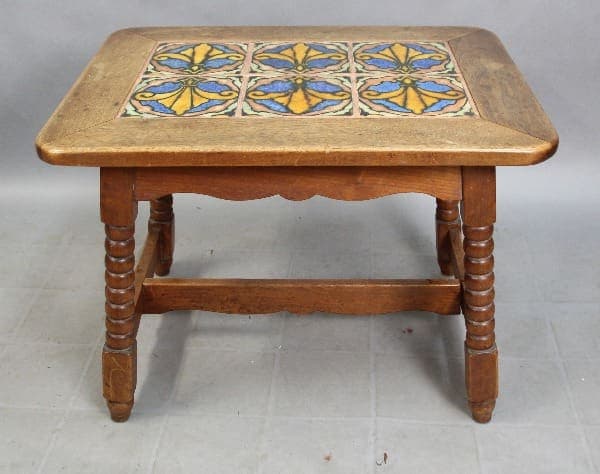 15324. Spanish Revival American Encaustic Tiled Table with a decorative blue and yellow tile inlay on the top surface, supported by four chunky, turned legs.