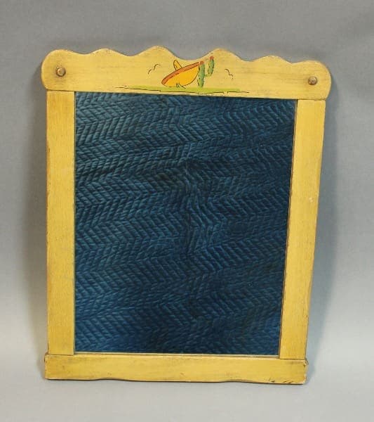 Vintage wooden washboard with a blue rippled metal scrubbing surface and a yellow frame decorated with a Rancho mirror with hand painted sombrero and cactus.