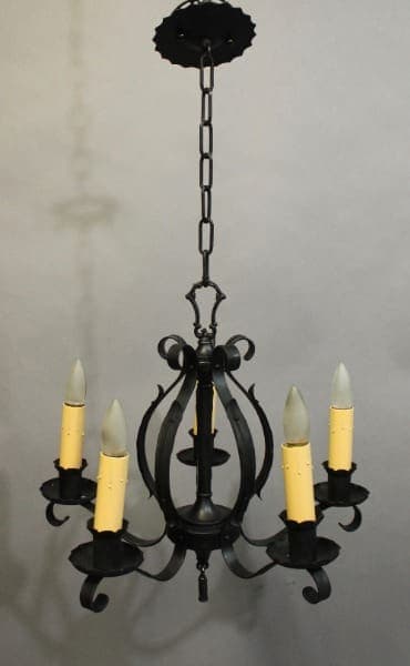 15935. 1920's Iron Chandelier With Simple Lines with six candle-shaped light bulbs, suspended by a chain, displayed against a gray background.