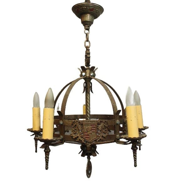 15994. Five Light 1920's Spanish Revival Tudor Chandelier With Crest Motif with a medieval design featuring a circular metal frame, ornate details, and six candle-like bulbs.
