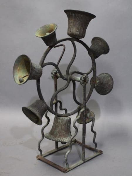 A rustic 16236. 1920's Spanish Revival Bronze Bell Carousel with multiple curved arms and cup-shaped holders on a square base.