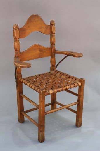 7970. Monterey Armchair w/ Ironwork with a curved backrest and woven seat, featuring armrests, displayed against a neutral background.