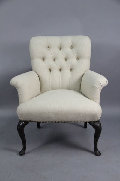 Elegant tufted armchair with dark wooden legs.