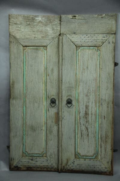 An old, weathered 13088. pair of rustic door with original patina, with faded white paint and visible signs of wear.