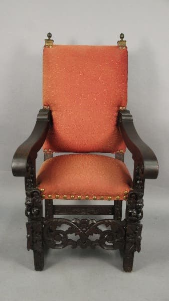 Ornate wooden chair with orange upholstery.