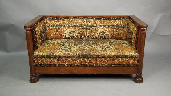 Vintage wooden sofa with colorful fabric upholstery.