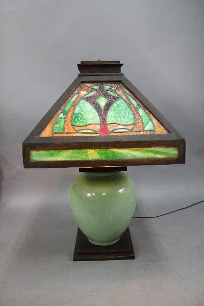 A 14015 large scale Arts and Crafts table lamp with great wood and a stained glass shade in green and purple colors.