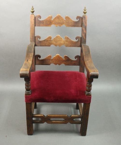 Wooden chair with red upholstered seat.