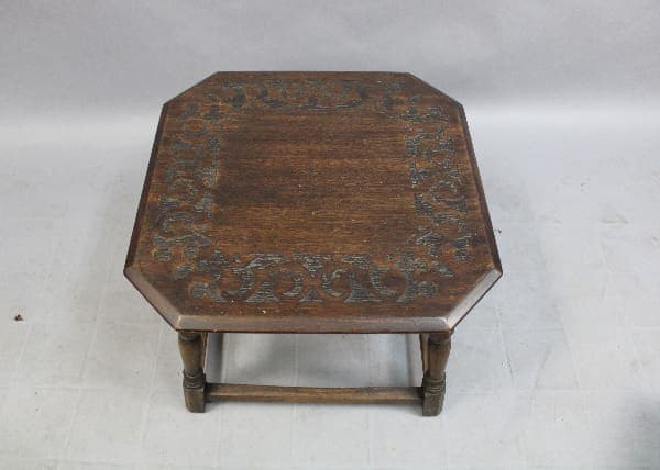 An 15114. Spanish Revival Side Table With Etched Top with ornate carvings on its surface and legs, against a plain background.