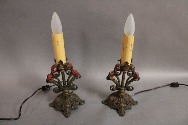 Two 15117. Pair of 1920's Lamps With Polychrome Finish designed to resemble candles, each with ornate floral brass bases, displayed against a gray background.