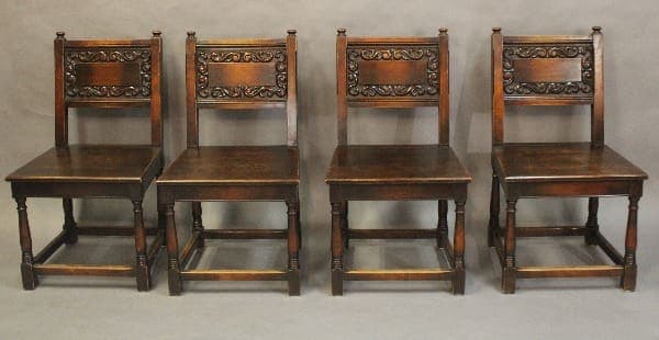 Four antique wooden chairs in a row.