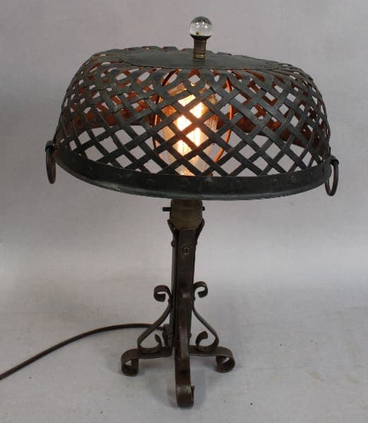 15283. 1920's Table Lamp With Woven Iron Shade with a lattice design shade and a crystal finial, illuminated from within, standing on a tripod base.