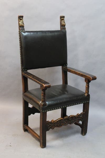 Antique wooden chair with black leather upholstery.