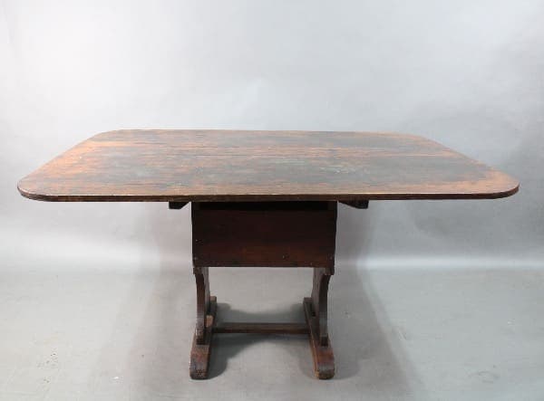 An antique wooden oval table with a weathered surface, supported by a sturdy base with four legs, isolated against a neutral gray background. - Product Name: 15340. Early Primitive Farm Table