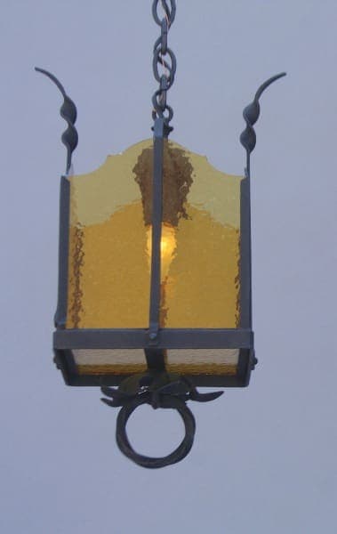 Hanging yellow lantern with decorative features.
