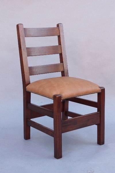 A 9800. 1910 Arts & Crafts Ladder Back Chair with a brown leather cushion and horizontal slat backrest against a neutral background.
