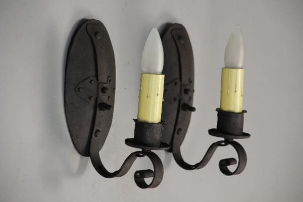 Black iron wall sconces with candles.