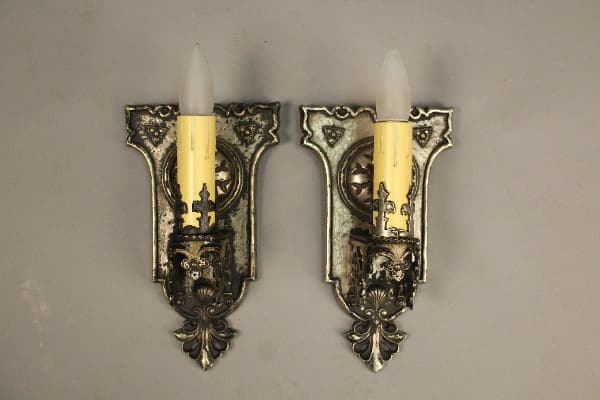 Pair of ornate wall sconces with candles.
