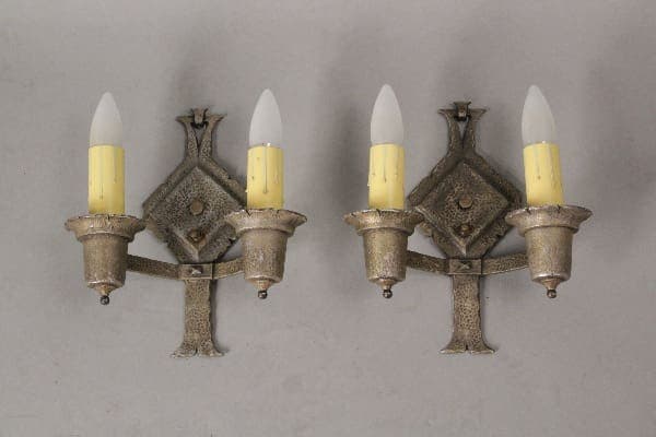 Pair of antique silver wall sconces with candles.