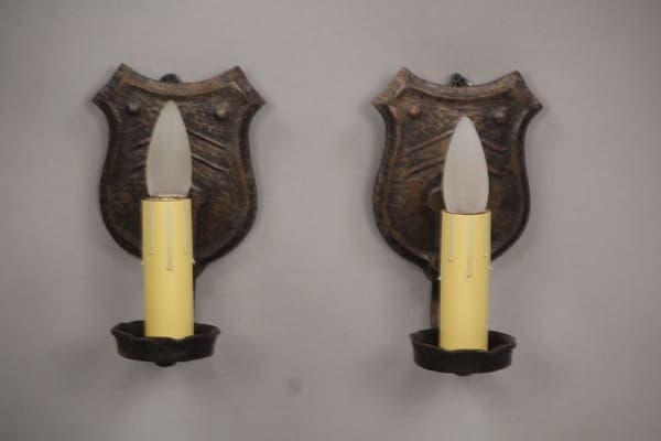 Pair of vintage shield-shaped sconces with bulbs.