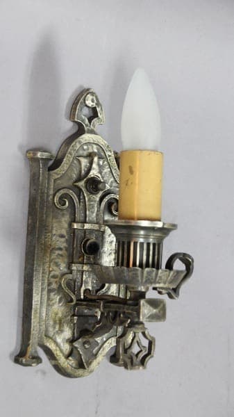 Vintage metal wall sconce with candlelight.