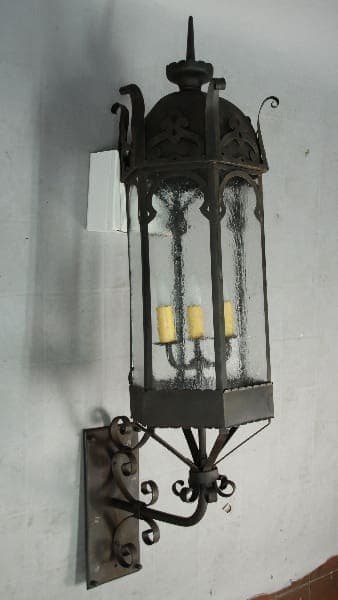 Ornate black wrought iron wall lantern.