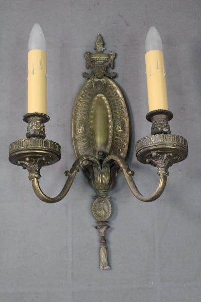 Antique brass wall sconce with two candles.