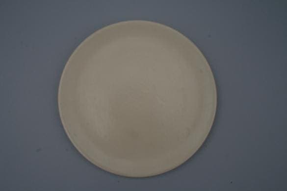 Plain round plate on a grey background.