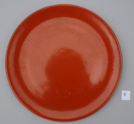 Red ceramic plate on gray background.