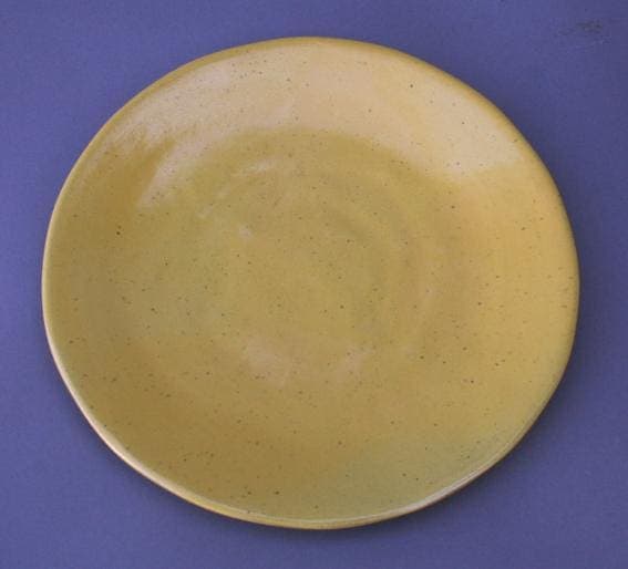Yellow ceramic plate on blue background.