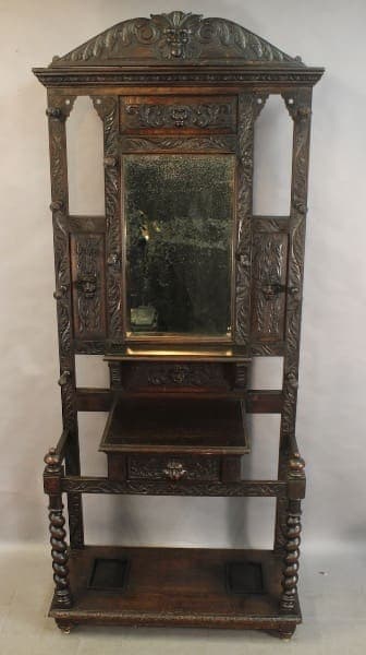 Ornate wooden hall stand with mirror.
