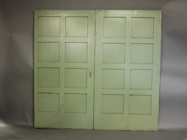 Green double doors with square panels.