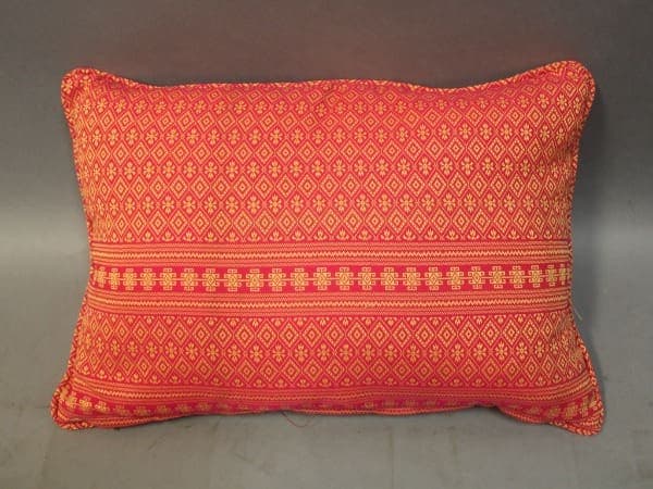 Red patterned rectangular cushion on gray background.
