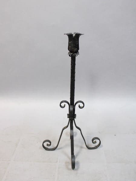 Wrought iron candle holder with ornate design.