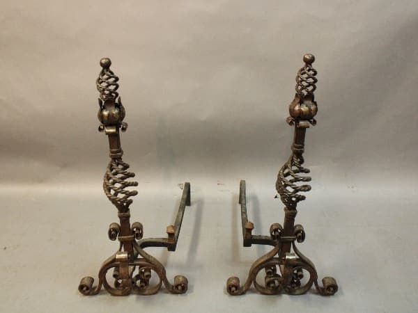 Ornate metal fireplace andirons with scroll design.