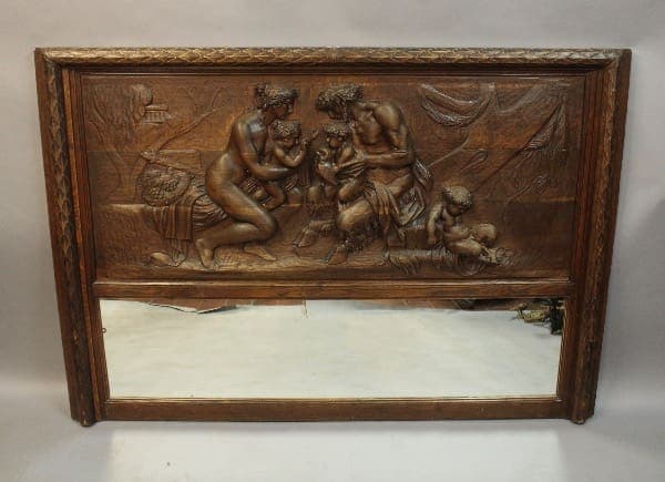 Wooden relief art with mirror, depicting figures.
