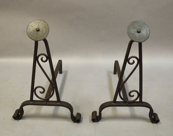 Decorative metal andirons with scroll patterns.