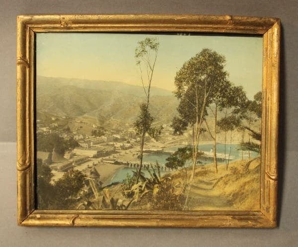Framed painting of a coastal landscape scene.