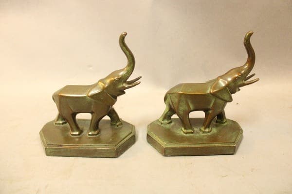 Two brass elephant bookends on display.