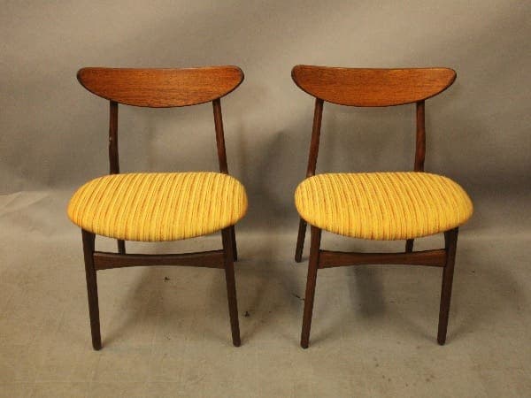 Two wooden chairs with yellow seats.