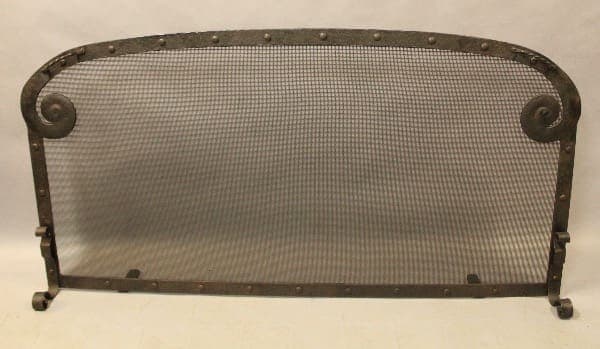 Vintage metal fireplace screen with mesh design.