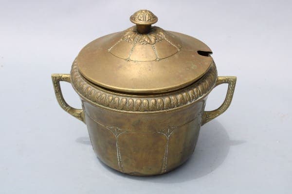 Antique brass pot with ornate lid.