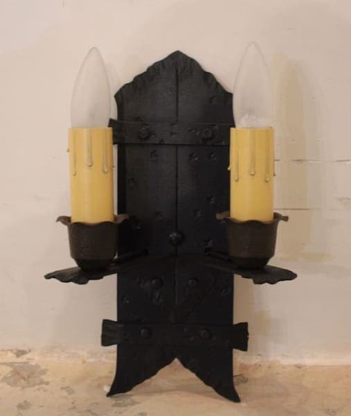 Black vintage wall sconce with two candles.